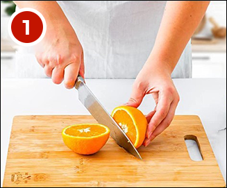 a person slicing an orange on a cutting board